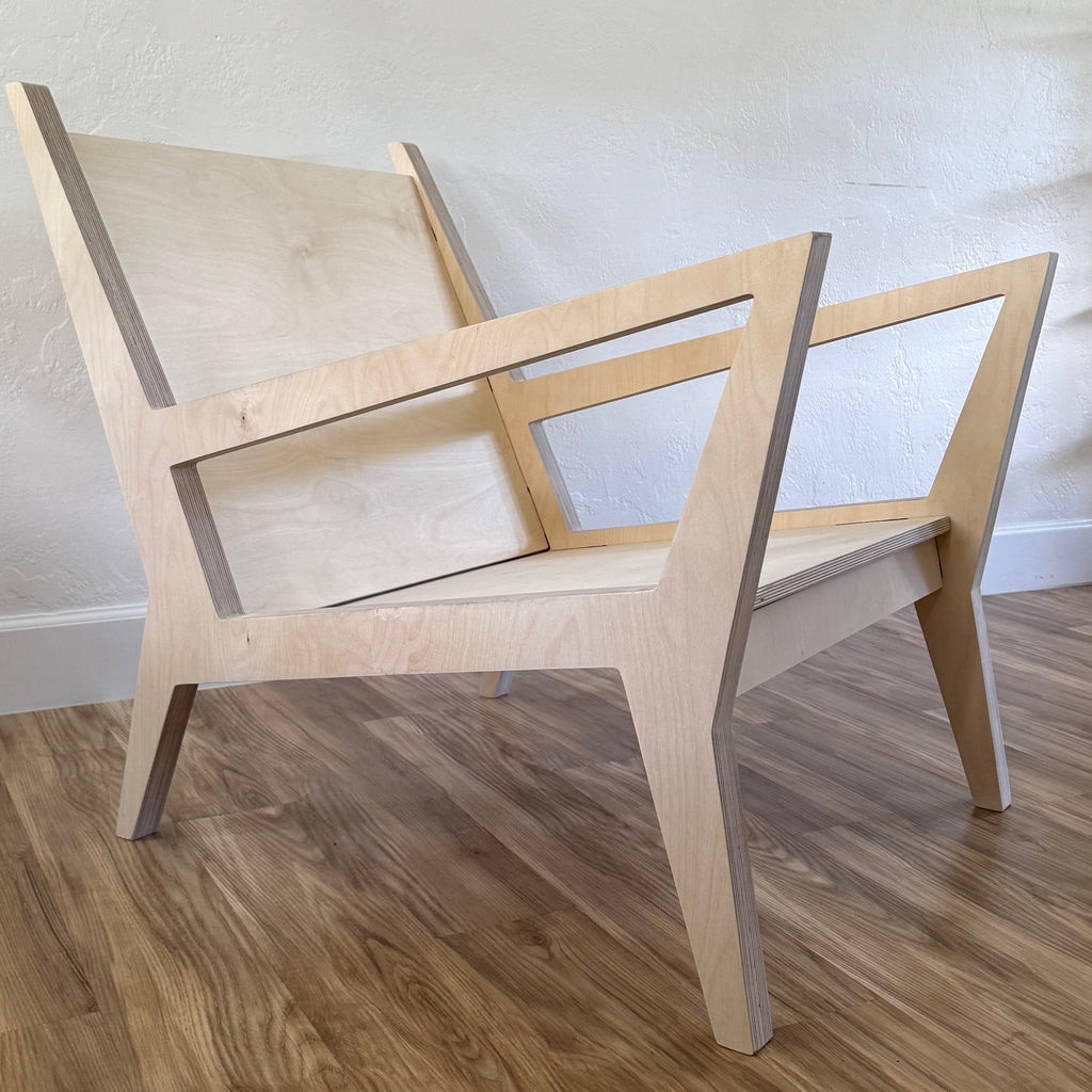 Wooden chair against a white wall with framed pictures